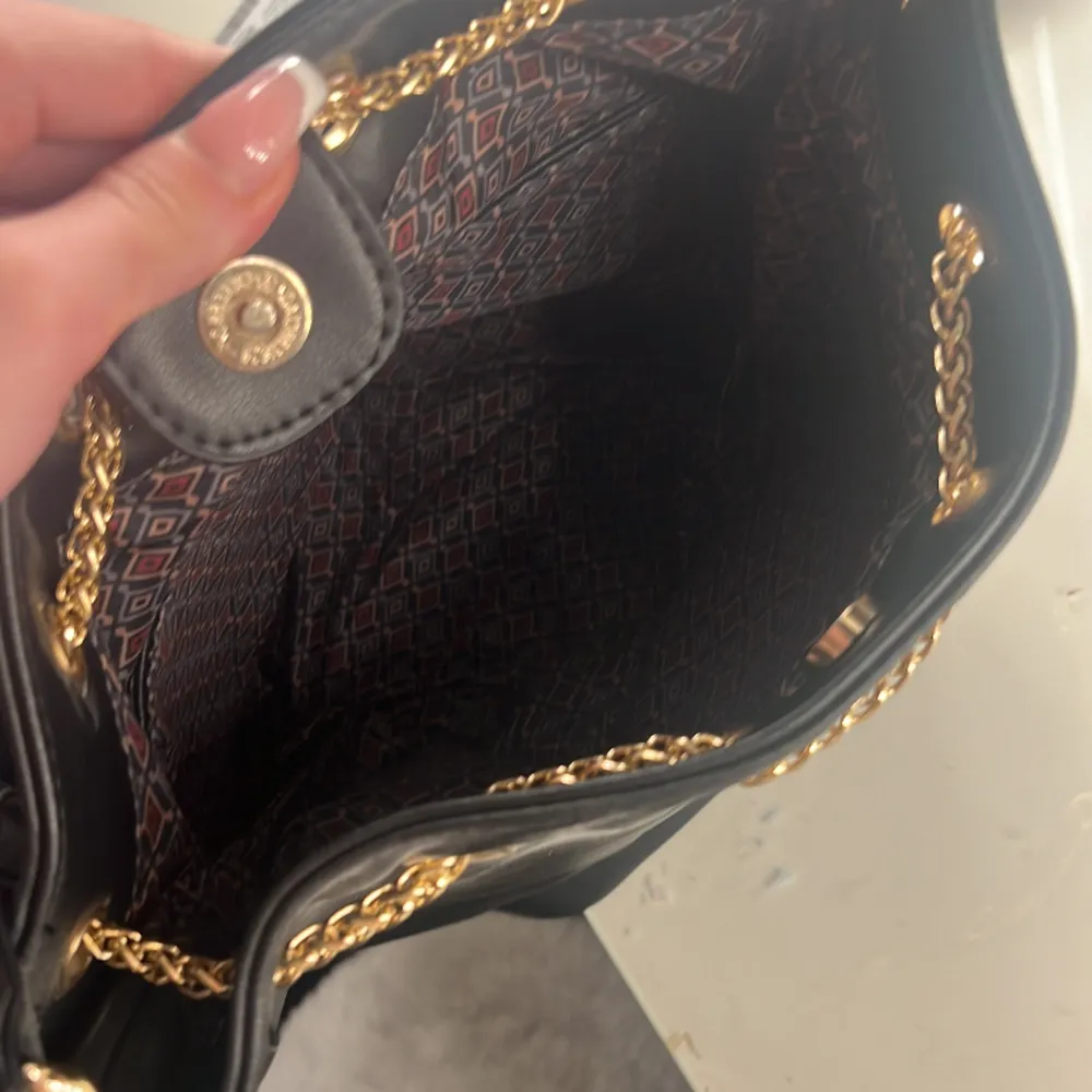 Aldrig använd! Svart handväska som är rymlig och fint mönster inuti! Finns minre fack inuti väskan💕. Väskor.