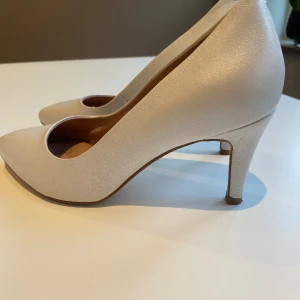 Tamaris pumps  - Fina pumps i färgen White pearl. Använda endast vid ett tillfälle. Jättefina!