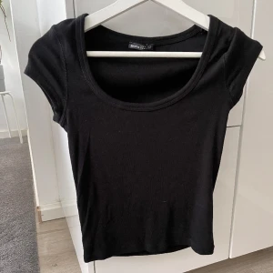 Svart topp - Säljer denna toppen i svart från Bershka som har en urringning framtill. Toppen är i stl m. Priset är inklusive frakt 