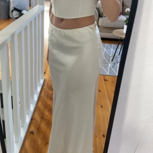 Lågmidjad långkjol  - Säljer denna vita lågmidjade kjolen från Gina i satin, storlek Xs aldrig använd, nypris 399kr