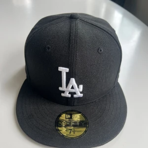 LA keps  - Huvudomfånget är 56,8 cm. Säljer på grund av att den inte kommer till någon användning. Lite fläckig på insidan på bak delen av kepsen som du kan se på bild 3. Men annars i fint skick. Skriv om ni har några frågor. 