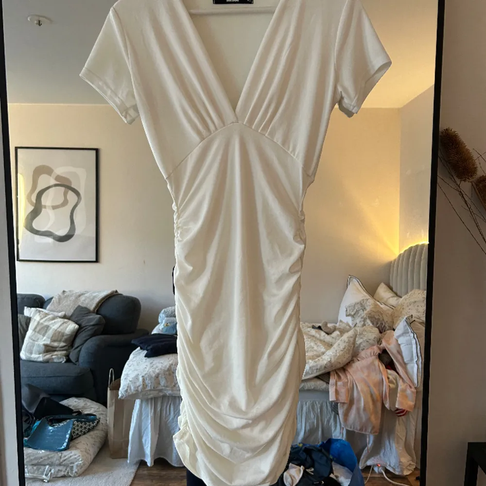 Fin vit klänning, med fina detaljer på sidan. Klänningen är i storlek xs men stretchig, köpt från Bik bok. Använd vid 1 tillfälle!. Klänningar.