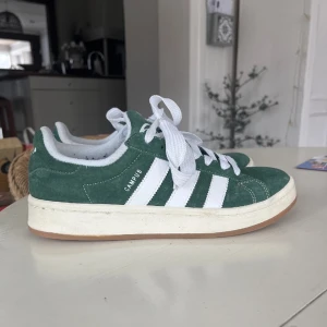 Adidas Campus 00s - Säljer dessa adidas campus 00s i färgen grön som är slutsålda. De är i storlek 40 men passar storlek 39. Skokartong medföljer ej men gröna skosnören gör. Skriv vid frågor! Mvh milly❤️