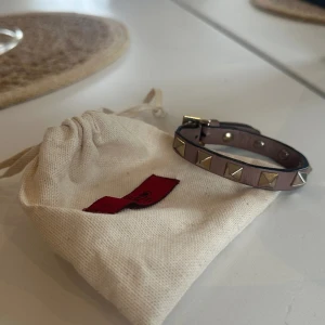 Valentino armband  - Säljer mitt valentino armband då det inte kommer till användning längre. Färgen beige. Har släppt lite lim i bandet men inget som syns när man har armbandet på! Nypris 2700 