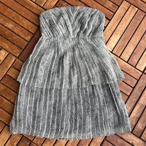 Axelbandlös klänning  - Aldrig använt. Knäpps med dragkedja i sidan av klännibgen. Man kan sy på straps, som ingår. Kontakta för fler frågor