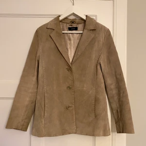 Beige kavaj i mocka - Sjukt cool kavaj i mocka köpt vintage!! Storlek 36.   Välanvänd och lite sliten, därav priset.  