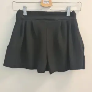 Soft stretchy mini shorts, high waist, big pockets and pleated details Almost gives a mini skirt feel when worn. Used but great condition. Custom made.