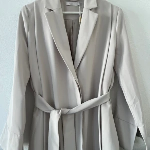 Wera kappa/ trenchcoat  - En trenchcoat från Wera. Liten fläck. Borttagbart skärp. Fin passform! 