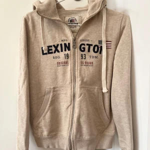 Hoddie Lexington  - Hoddie i beige färg, bra skick av märket Lexington. 