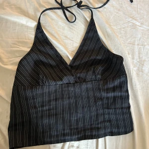 Svart randig linne från Motel - svart halternerck från Motel med vita och gröna ränder knyts i nacken och har dragkedja på sidan. fint skick! 