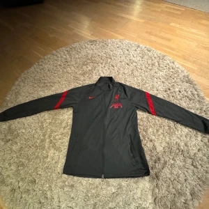 Liverpool Träningströja - Säljer min Liverpool träningströja, använd en del men sparsamt. Skick 8/10. Inköpt på Unisport för 1399:- Storlek M men passar även L