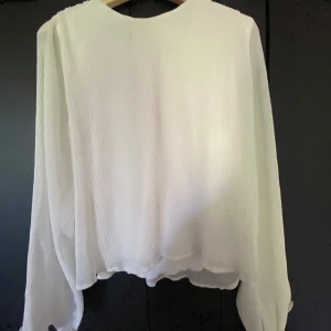 Wave Tröja - Jätte fin vit tröja med lös passform, tröjan har utsvängda och  voluminösa armar och vågiga kanter. 