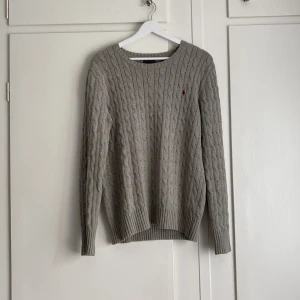Ralph Lauren kabeltröja - Riktigt klassiskt snygg stickad Ralph Lauren tröja! Givetvis äkta! Väldigt bra skick! Storlek är svår att säga, det står ålder 18-20 så skulle säga att den passar upp till L med en tajt passform och S/XS med mer loose fit☺️