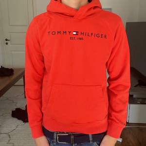 En orange/röd tommy hilfiger tjocktröja som har blivit lite liten för mig, det finns en liten fläck (finns bild)