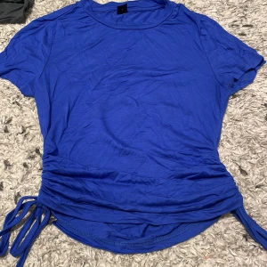 Blå tshirt - Blå tight tshirt med snören på kanterna, köpt från shein och passar mig inte längre. Fint skick och stretchig material