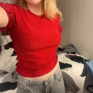 Glittrig Röd T-shirt  - Glittrig gullig och julig T-shirt med volanger på ärmarna. Perfekt till julafton eller en julfest. Säljer då den inte passar.💗❤️