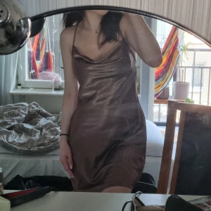 Brun slip dress - Säljer denna fina bruna slip dress.💕 Haft den ett fåtal gånger och är i perfekt skick. 💕 Har kortat axelbanden vilket går att länga igen och har även sytt en hake bak som går att stänga vilket ses på bild! Skriv vid funderingar!💕