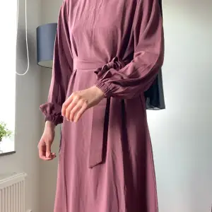 Säljer abaya då jag är för lång för den. Nyttskick och kommer med matchande bälte. Fint ogenomskinligt material, har osynlig dragkedja i nacken och fickor! Behöver bara strykas. Längd är 133cm. Jag är ca 173cm lång för referens🩷Köpt för 500