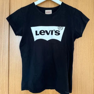 Levis t-shirt - Svart och vit Levis t-shirt. Bra kvalitet. Den har en ganska figurnära passform. Står att den är storlek 14, jag skulle säga att den passar som XS/S!