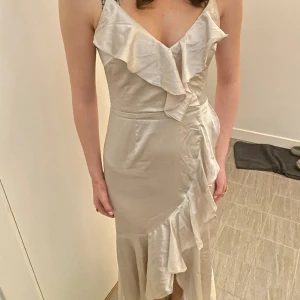 KLÄNNING/BALKLÄNNING❤️‍🔥 - Fin beige klänning med volanger och slitt på sidan, bara inget för mig! Så bara provad 1 gång