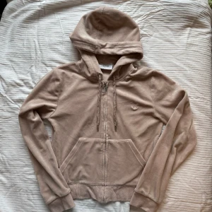 Juicykofta  - Kofta från Juicy Couture. Beige/puderrosa. Jättefint skick.  J:et på dragkedjan har tappat liiiite färg men absolut inget som stör. Samt ett litet ”jack” i velouren men detta är heller inget som stör i mitt tycke. Båda defekterna syns på bild. 