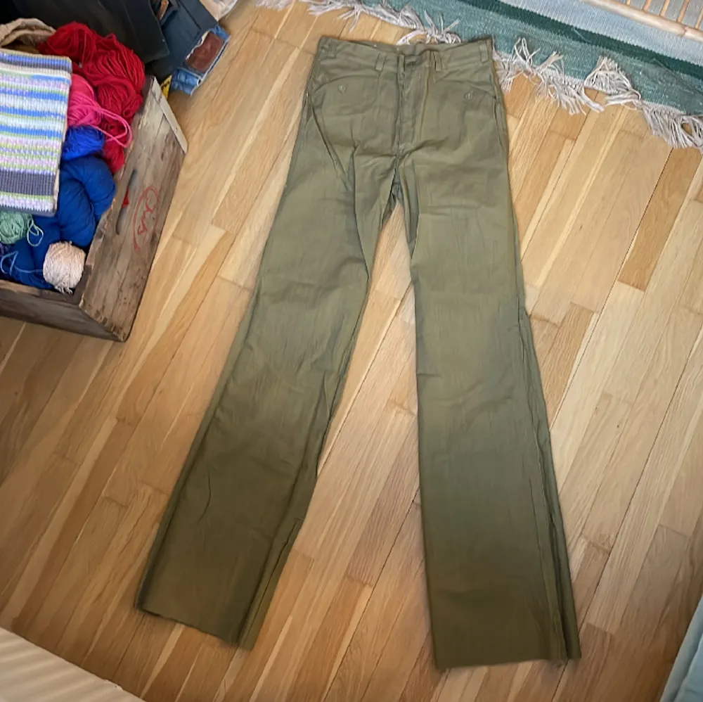 Vintage utsvängda byxor från Dobber, grönbeige färg. Helt nya med lapp kvar, endast legat på lager.  Obs det är rålängd, de är alltså inte fållade utan bör sys upp i ens egen längd. Märkta size 30, inseam 36.  Mått cm: Midja: 35 Höft: 43 Ben: 88  . Jeans & Byxor.