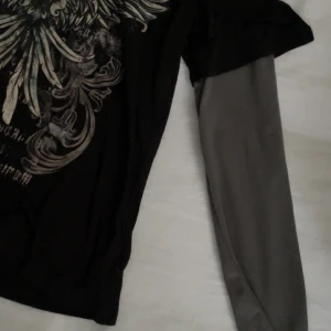 Långärmad ”emo” tröja - En svart t-shirt med tryck tillsammans med gråa ärmar som sitter i tröjan. Från shein och använt fåtal gånger så fint skick! Tryck ej på köp nu kontakta mig först för har ej kopplat mitt kort än vilket jag kommer göra om någon vill köpa❗️❤️