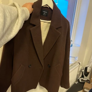 Kort kappa - Säljer min jättefin bruna kappa från Lindex. Mörkbrun färg och bra skick. 