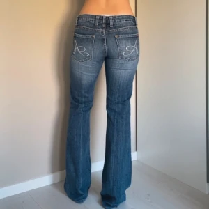 Y2k jeans - Sjukt snygga low waisted jeans med a på fickorna. Midjemåttet är 76 cm och innerbenslängd 81 cm. Skriv för fler bilder eller vid frågor! Bilder från förra köparen!!! Använd gärna köp direkt❤️