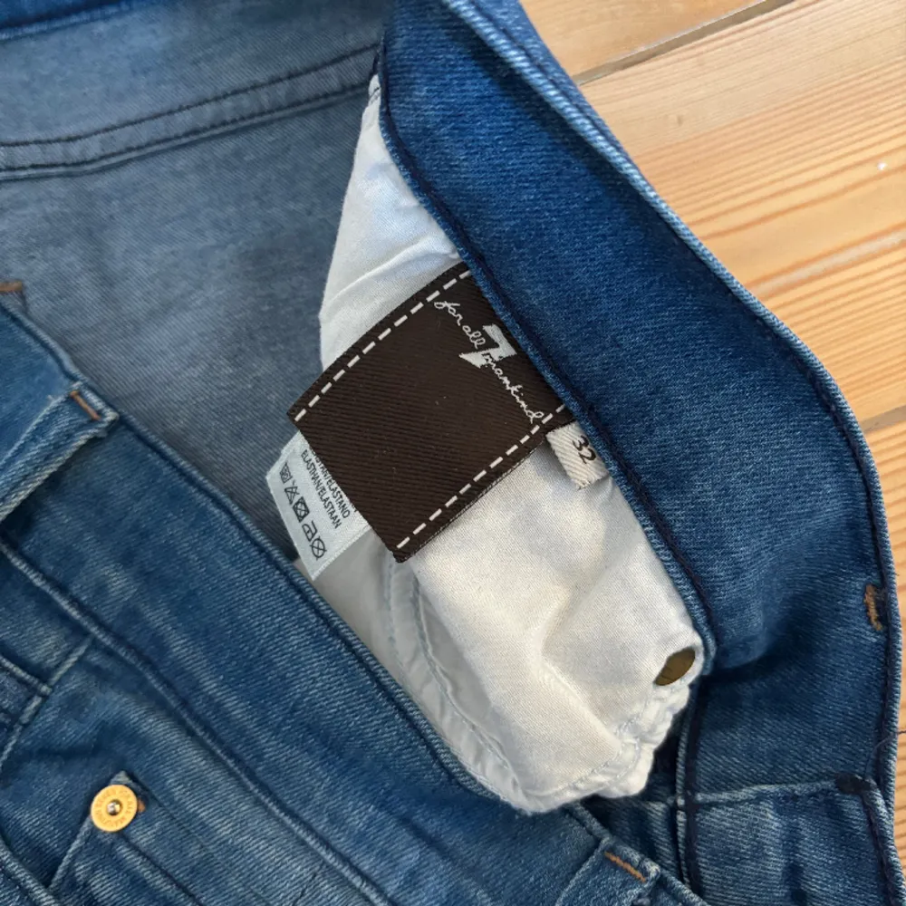 Blåa Bootcut jeans från 7 for all mankind.  Fin tvätt (något ljusare blå), med lite slitningar vid hälen.   Använda men gott skick (bortsett från slitningarna).   Storlek 32. . Jeans & Byxor.