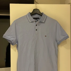 TH pike ljusblå slimfit  - Hej säljer min TH pike, aldrig använt och lappen sitter kvar som bevis, ordinarie pris ligger på runt 600kr