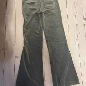 Juicy couture mint gröna - Detta är ett par juicy couture byxor i färgen mint grön/grön dessa byxor har blivit använda en gång. Jag är 170cm och de går hela vägen ner till fötterna utan problem det är guld detaljer och fickor därbak. Hämtas upp i Vasastaden orginal pris 1300