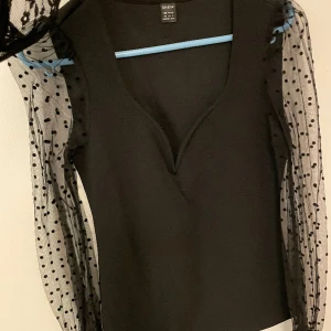 Blus - Svart blus med genomskinliga ärmar, endast testad storlek xs. 