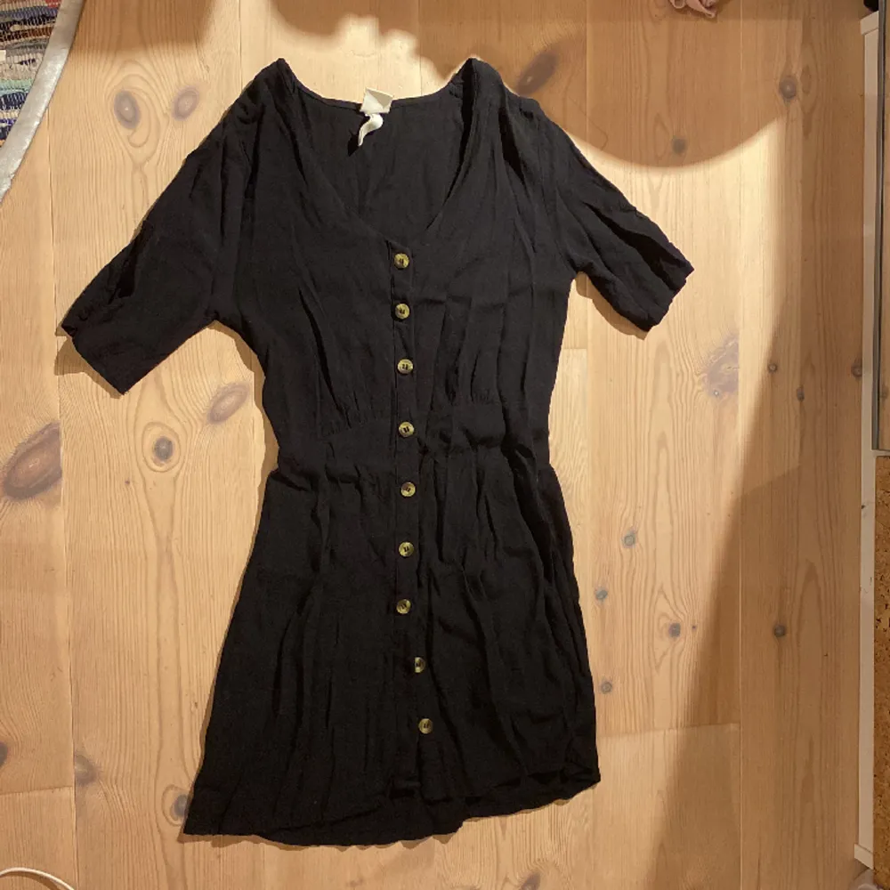 Strl:34 En söt svart klänning med fina knappar, i fint skick och väldigt väl använd.🫶🏻❤️. Klänningar.