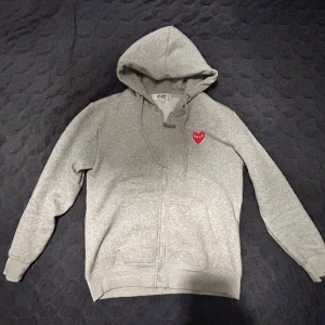 CdG Play – Zipped Hoodie - Endast använd 1-2 gånger – Helt nytt skick. Storlek medium.