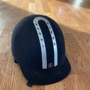 Ridhjälm Hansbo. - Fin hjälm i fint skick. Ett år gammal. Stl 57. Aldrig skadad!
