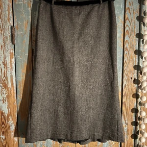 Lätt klockad pennkjol HM - Stl M/38 lätt klockad pennkjol i tweed-tyg från H&M, sött sammetsskärp i midjan, oanvänd. 