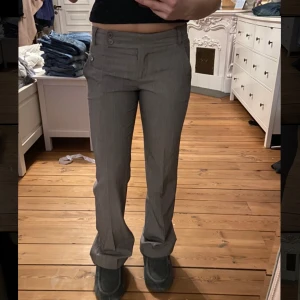Lågmidjade kostymbyxor  - Gråa Lågmidjade kostymbyxor. Jag på bilden är 165💞 Innerben: 78  Rakt över midjan: 37