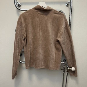 Ribbad sammetströja  - En ribbad tröja med krage i sammets tyg från Gina tricot. Väldigt fint skick då jag inte alls använt den mycket.  Storlek S och är sann i storlek tycker jag! 