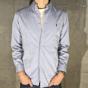 Ralph Lauren skjorta  - Ralph lauren skjorta i färgen blå. Storlek M och modellen är 186 cm. Nyskick, inga skavanker. Nypris 1495 kr, köp för endast 599kr.