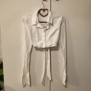 Skjorta adsgn - Croppad skjorta från adsgn med öppen rygg och knytning. 