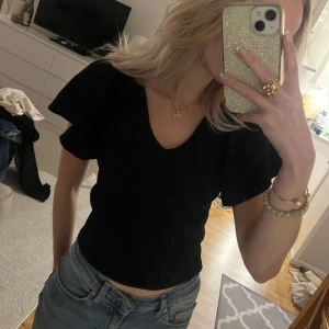 Svart topp  - Topp med volangärmar och går lägre i ryggen med knytband, superfin och nyskick💕🫶🏼