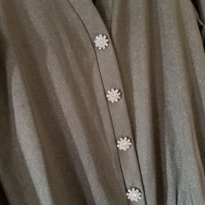 Khaki kofta  - Glittrig khaki kofta med 4 strass knappar 