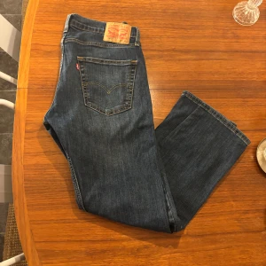 Levi's 502 mörkblå jeans W31 L30 - Säljer ett par Levi's 502 jeans i mörkblå denim med klassiska kontrastsömmar och femficksdesign. Jeansen har rak passform och normal midja, perfekt för en clean och tidlös look. Ikonisk läderpatch bak och röd Levi's-tagg på bakfickan.
