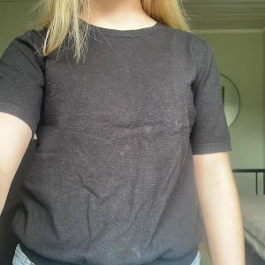 Svart stickad tröja från H&M - Svart stickad tröja från H&M i storlek S. Tröjan har rund hals, korta ärmar och ribbade muddar vid ärmslut och nederkant. Enkel och clean design som funkar till jeans eller kjol. Perfekt för dig som gillar basic och stilrent.