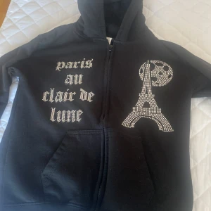 Svart hoodie med Paris-motiv XL - Mycket fin kofta i bra stick och helt ny har bara tästat den och den passa Inte mig. De är en fin kofta