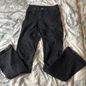 Svarta bootcut jeans från SHEIN - Svarta jeans från SHEIN i bootcut-modell med hög midja. Klassisk femficksdesign och dragkedja med knapp framtill. Jeansen är tillverkade i ett jeansmaterial och har en snygg, tidlös look som passar till allt.