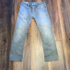 Grå jeans från Diesel - Snygga grå jeans från Diesel med klassisk femficksdesign och diskret logga på myntfickan. Jeansen har raka ben och normal passform, perfekta till sneakers eller boots. Materialet är mjukt och skönt bomullstyg med en lätt tvättad look.