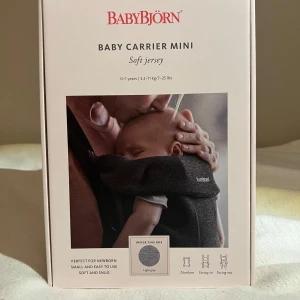 BabyBjörn Baby Carrier  - BabyBjörn Baby Carrier Mini i ljusgrått, tillverkad i mjuk jersey. Bärselen är liten, smidig och enkel att använda för nyfödda. Justerbar huvud- och sittdel, perfekt för att bära bebisen nära. Materialet är mjukt och följsamt för extra komfort. Aldrig öppnad ur förpackningen så sprillans ny!! Ny pris 1159kr