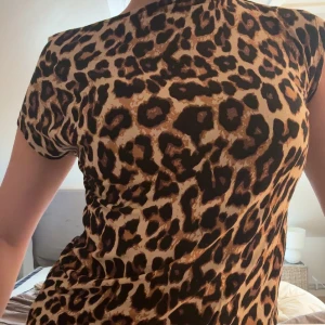 Leopardmönstrad topp med kort ärm - Säljer en snygg leopardmönstrad topp i beige och bruna toner. Modellen är figurnära med korta ärmar och rund hals. Perfekt för dig som vill sticka ut med ett djuriskt print. Materialet känns mjukt och följsamt mot kroppen. Säljer pga kommer inte till nån användning🩷